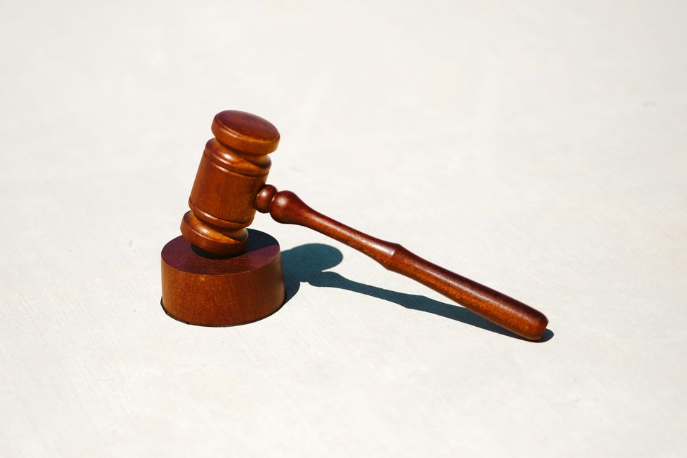 brown wooden gavel on white surface.