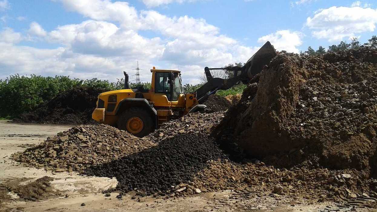 Bucket loader working in a composting facility for dried sewage sludge and green waste
