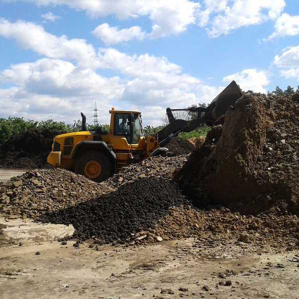 Bucket loader working in a composting facility for dried sewage sludge and green waste