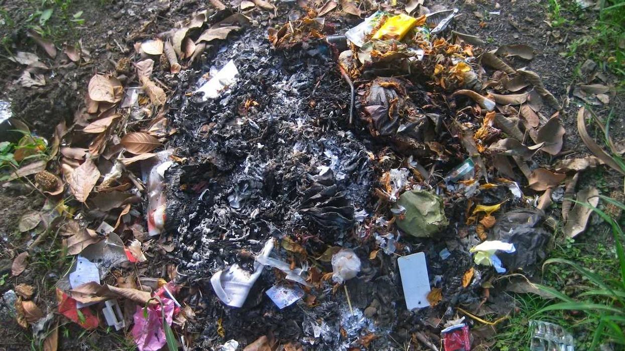 burn pile with partially consumed household trash
