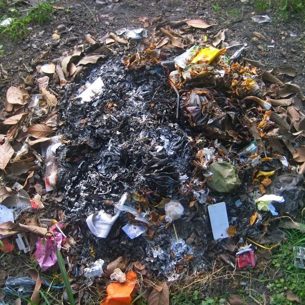 burn pile with partially consumed household trash