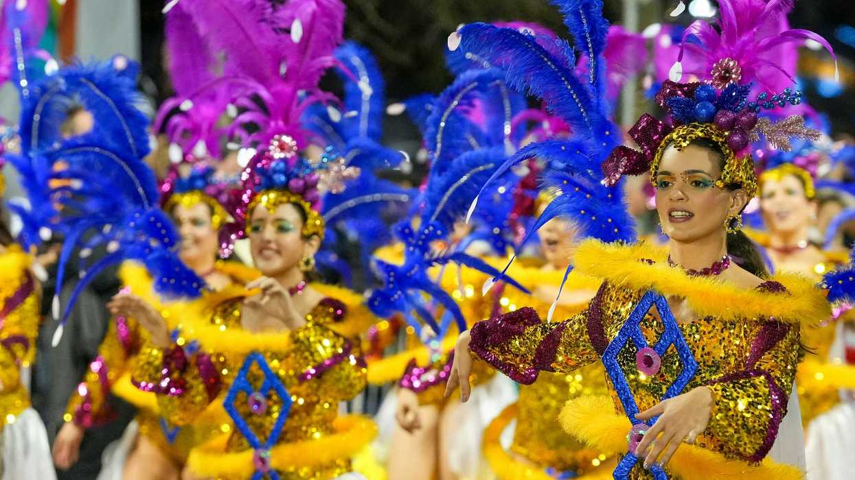 Carnival dancers parade in vibrant costumes.