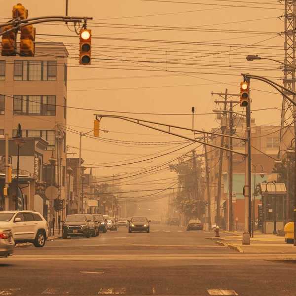 cars on a city neighborhood street amidst dirty air