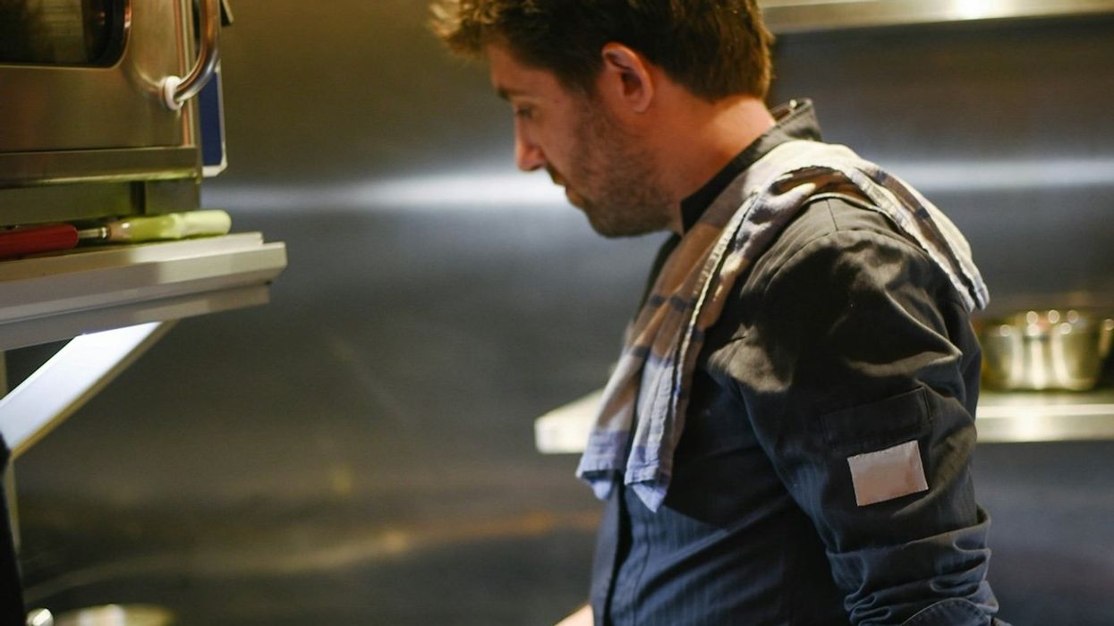 Chef cooking with frying pans on gas range