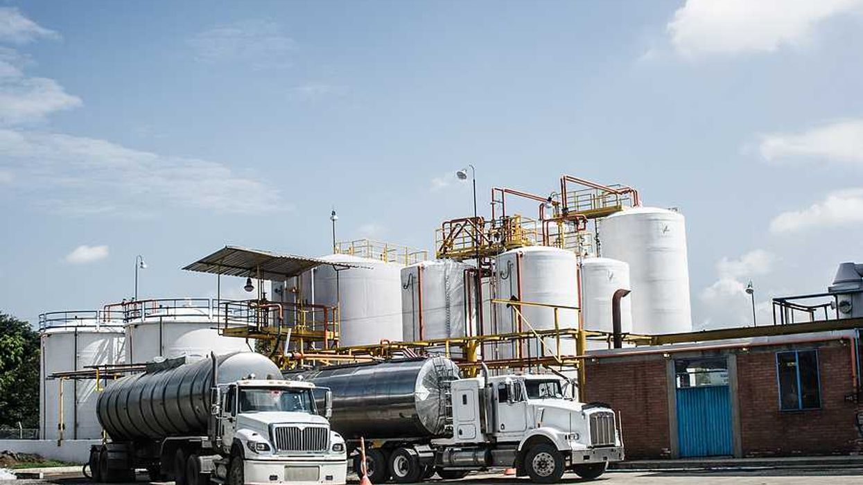 Chemical plant with trucks parked in the road in front of silos