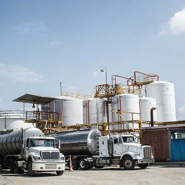 Chemical plant with trucks parked in the road in front of silos