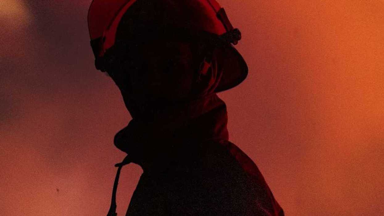 Chest-up view of firefighter in profile with mostly obscured face, faced towards the camera
