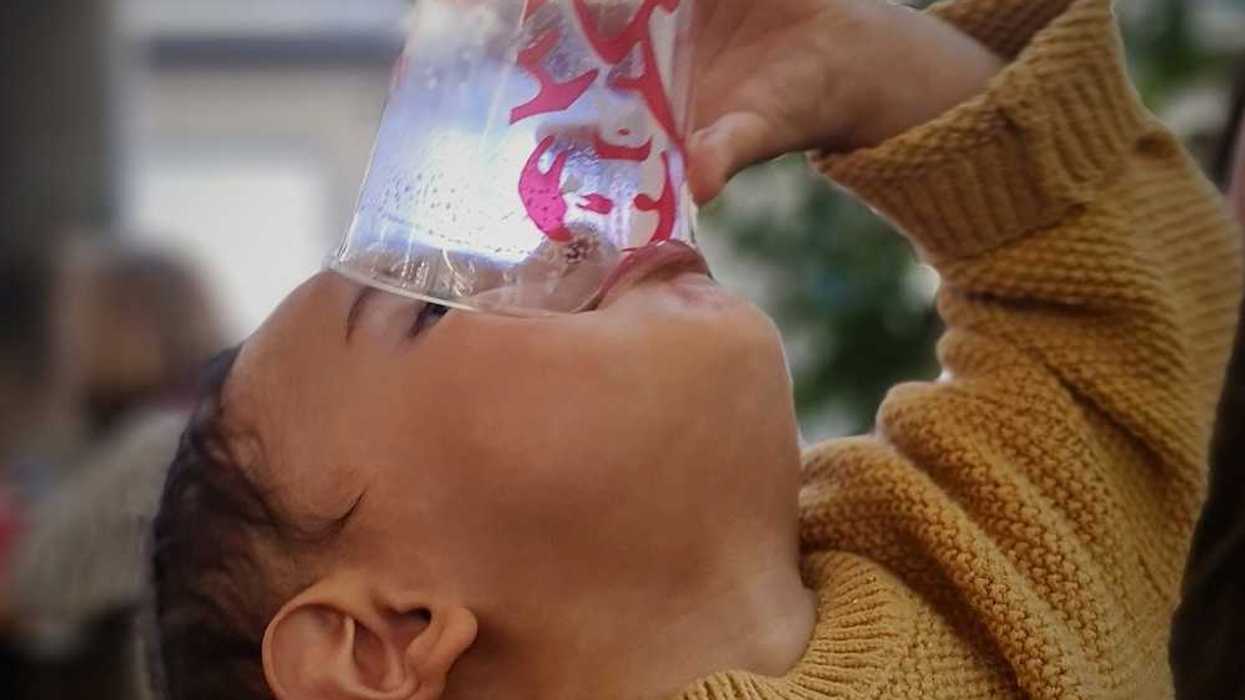 Child draining the last drop from a cup of water