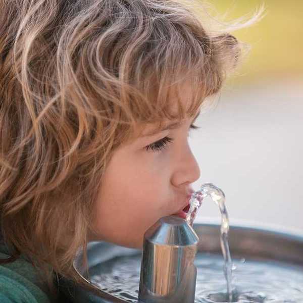 Child drinking from drinking fountain