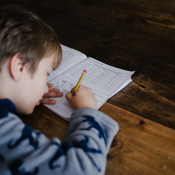 Child taking a test in a paper testing booklet.