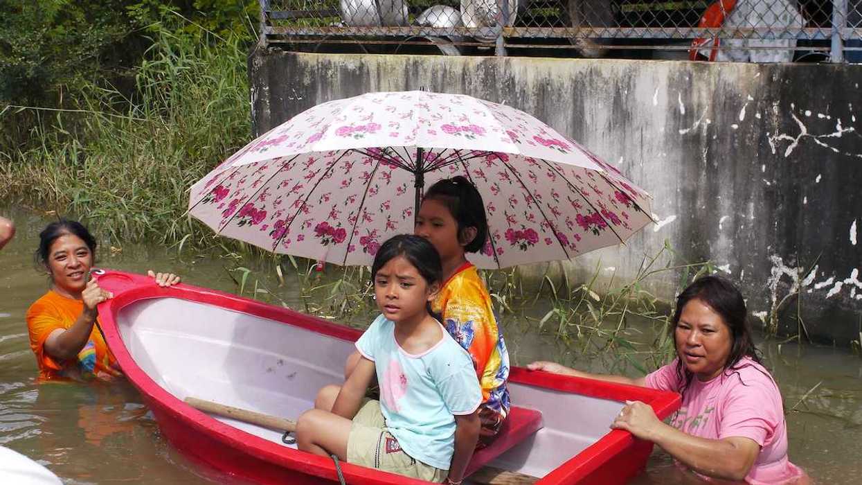 Children being transported through deep water in a small plastic dinghy during the monsoon flooding of October 24 2010 in Nakhon Ratchasima Thailand.