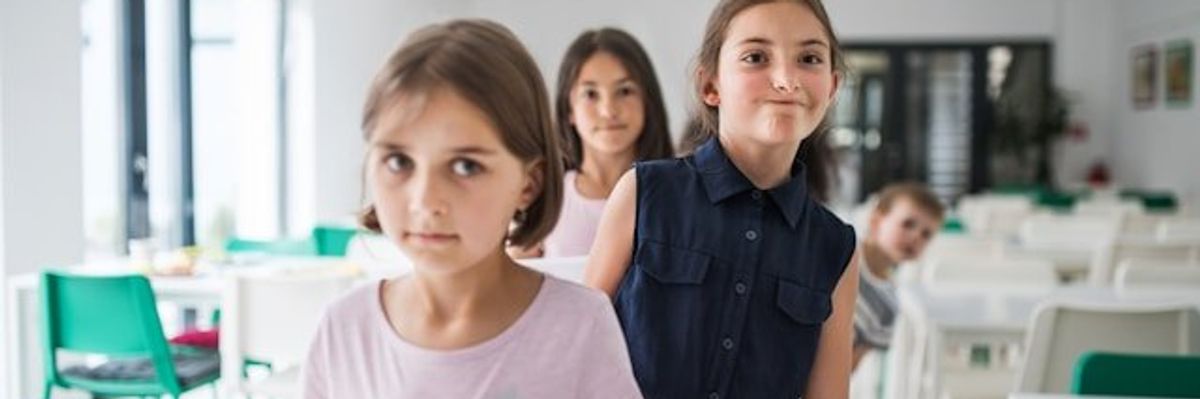 Children lining up in a school cafeteria.