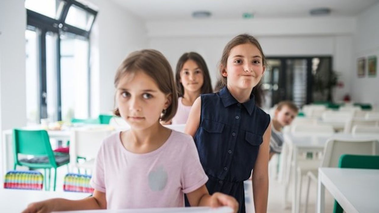Children lining up in a school cafeteria.
