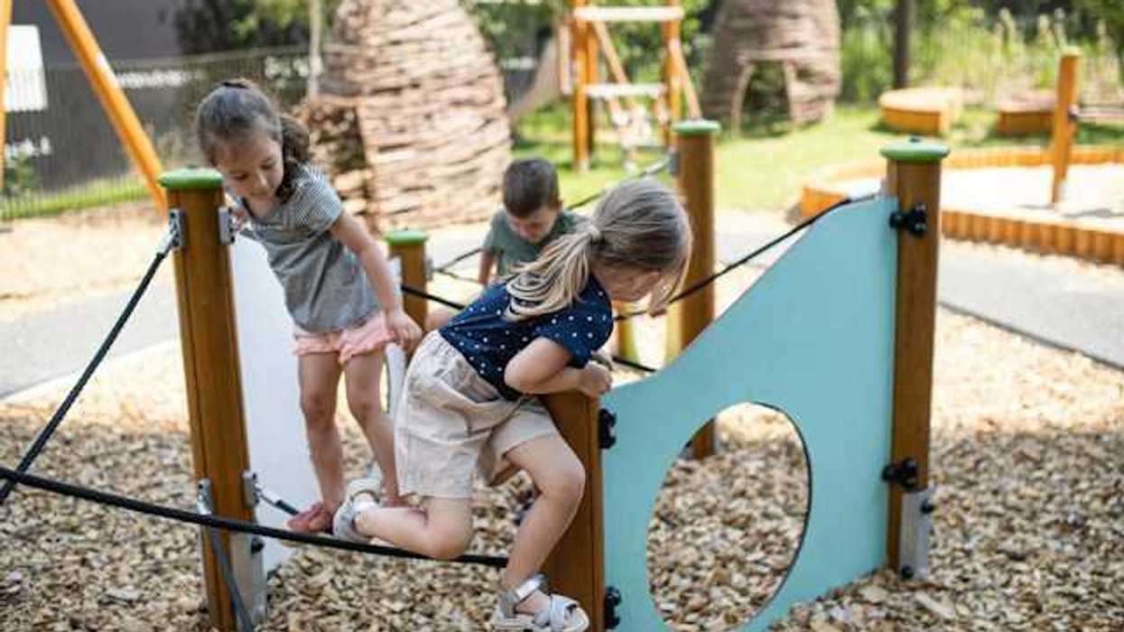 Children playing on play structures in a park