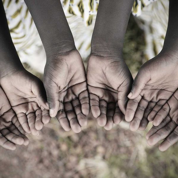 Children's cupped hands asking for help.