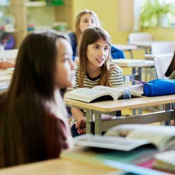 Children sitting in a classroom with books on their desks
