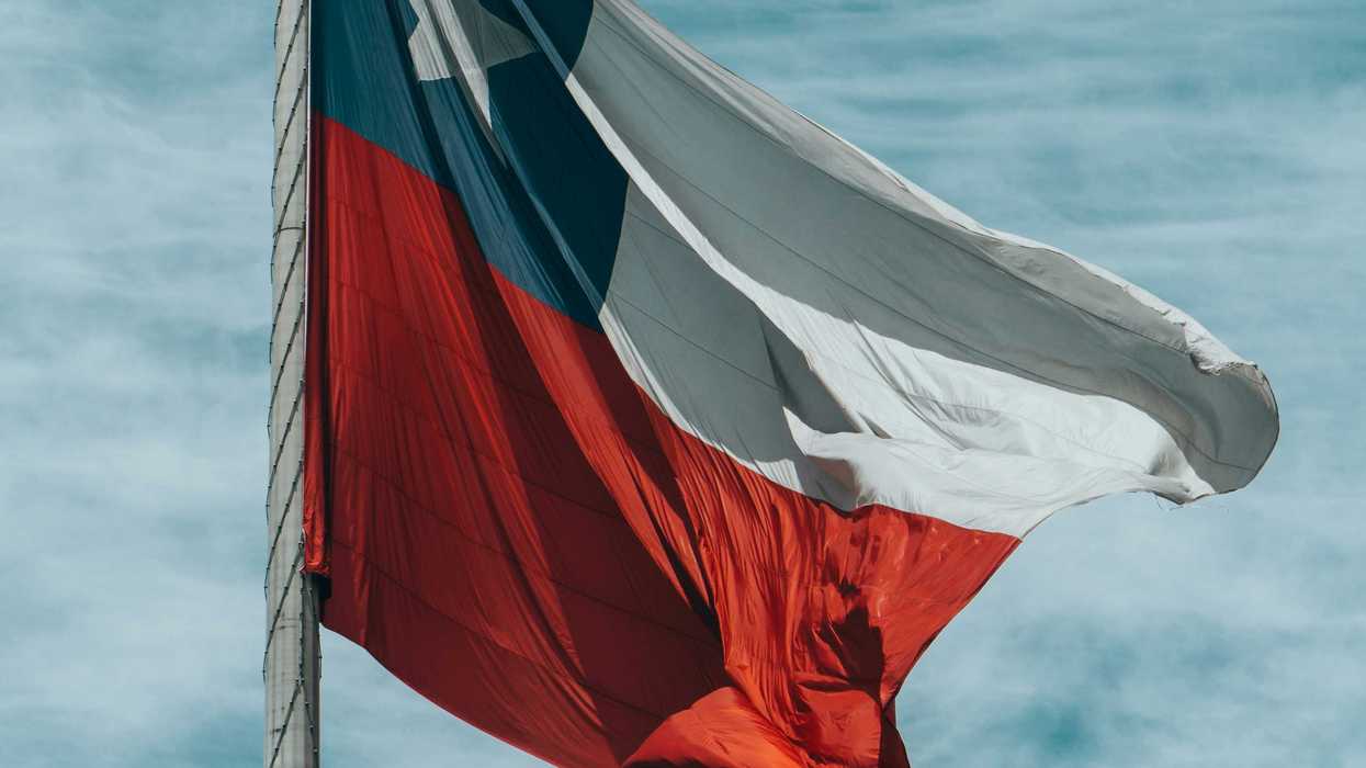 Chilean flag waving against a cloudy blue sky.