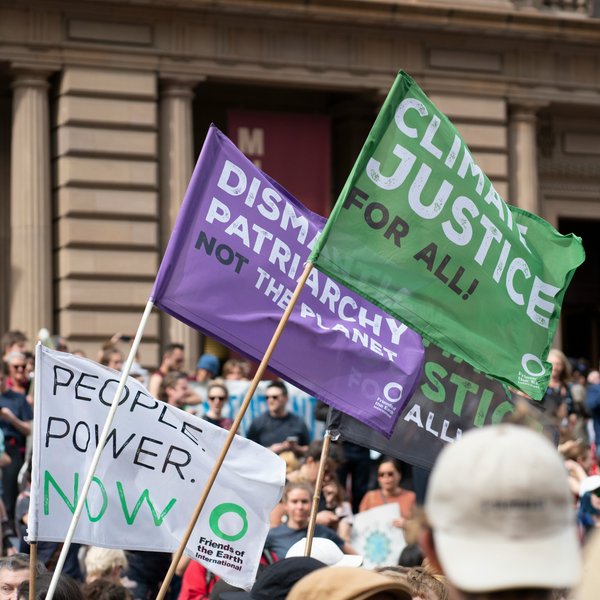 climate protest in which activists are holding flags saying climate justice for all