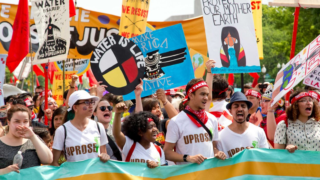 Climate protestors in a large group holding signs.