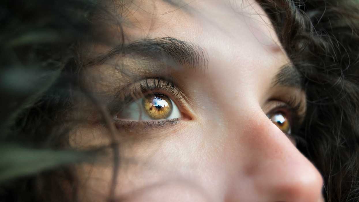 closeup photo of person's amber colored eyes as they look up.