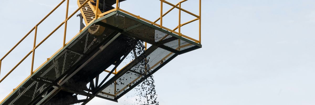 Coal being dropped onto a pile from a tall conveyer belt.