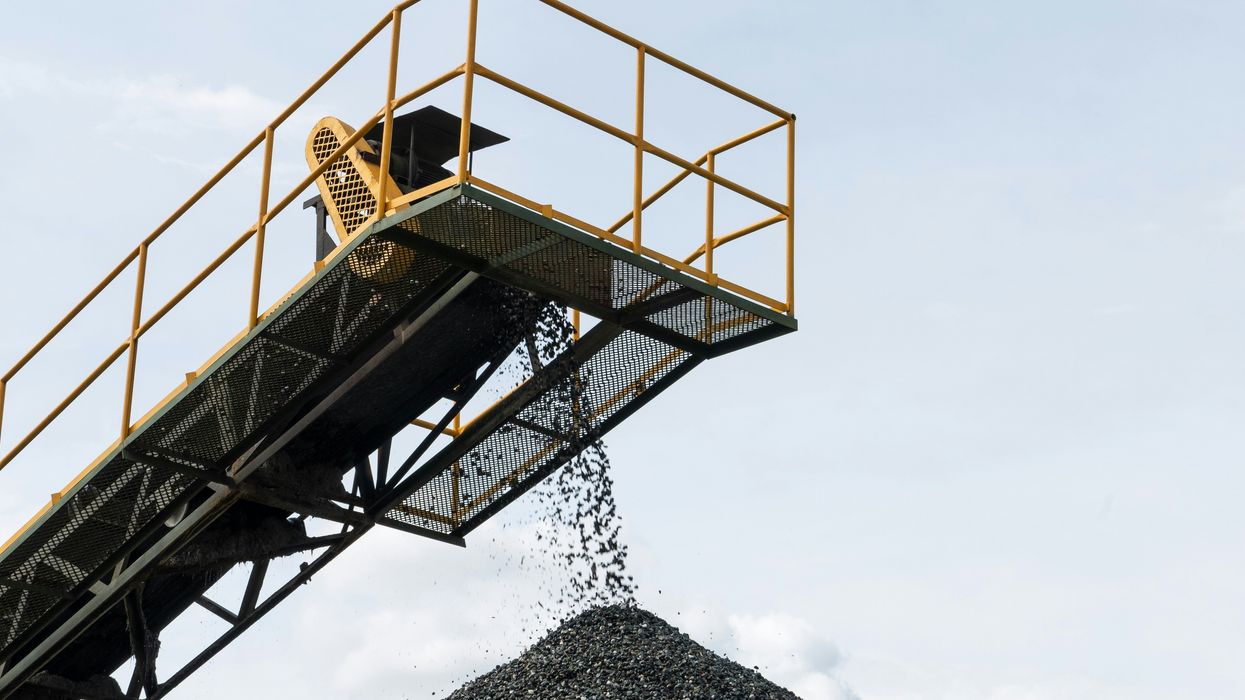 Coal being dropped onto a pile from a tall conveyer belt.