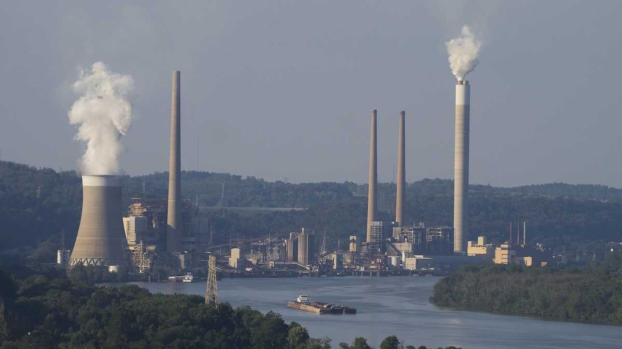 Coal fired electricity power plant along a river with a barge.