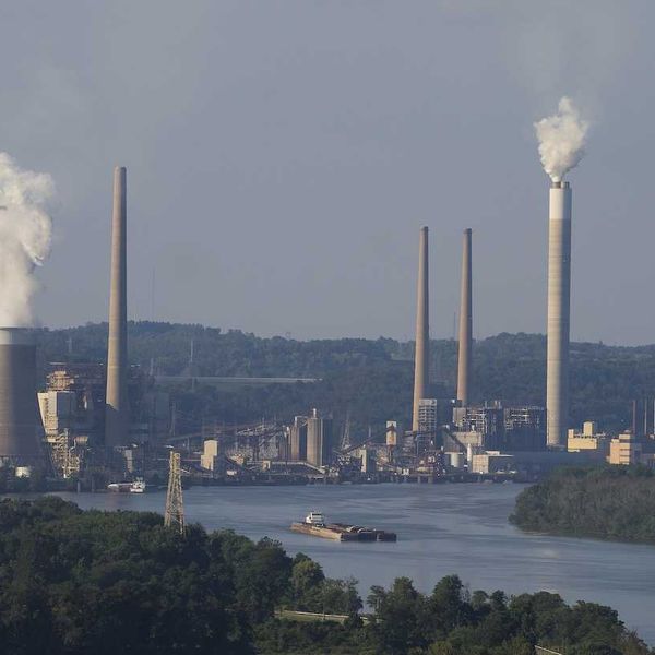Coal fired electricity power plant along a river with a barge.
