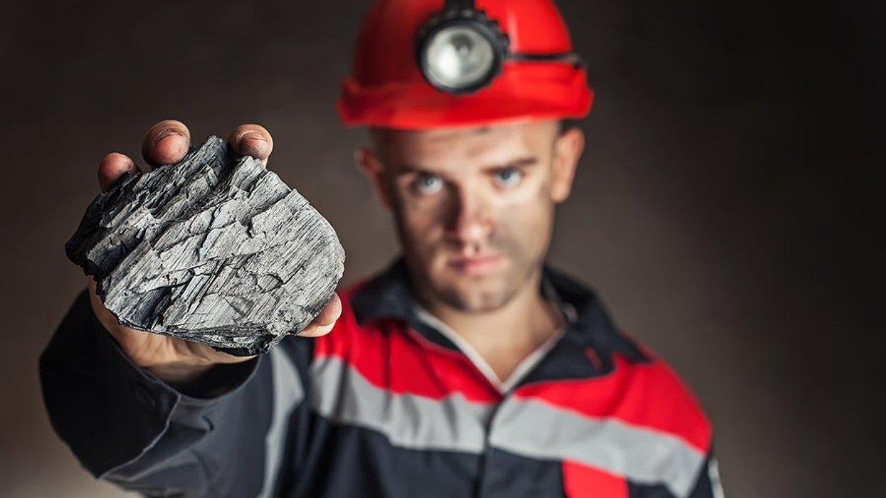 Coal miner holding a lump of coal
