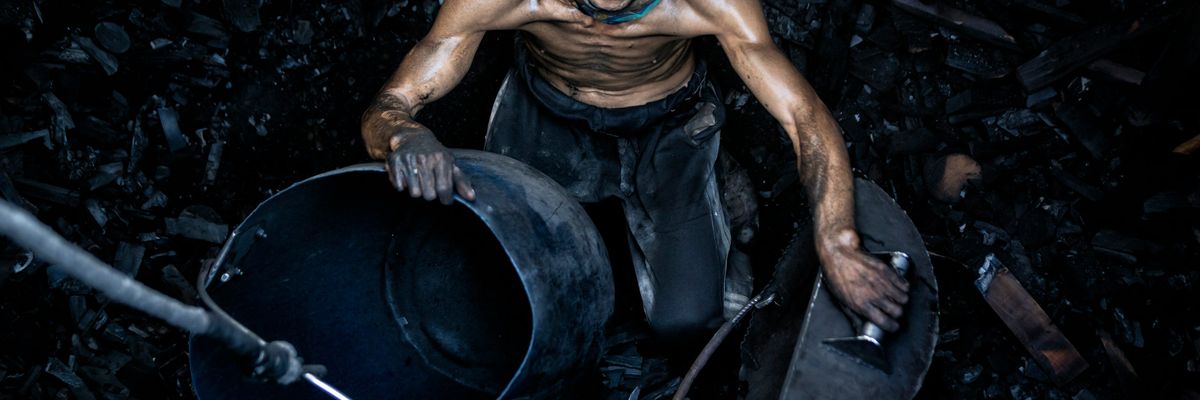 Coal miner sending coal up to the surface in a bucket.