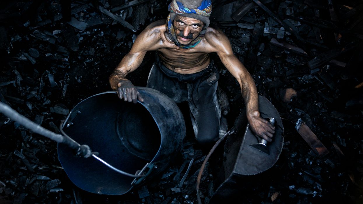 Coal miner sending coal up to the surface in a bucket.