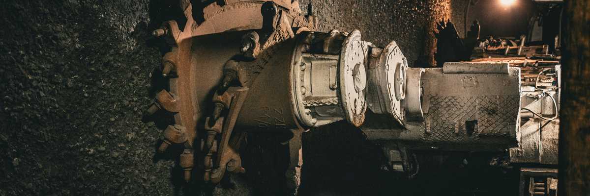 Coal mining equipment digging into a coal seam.
