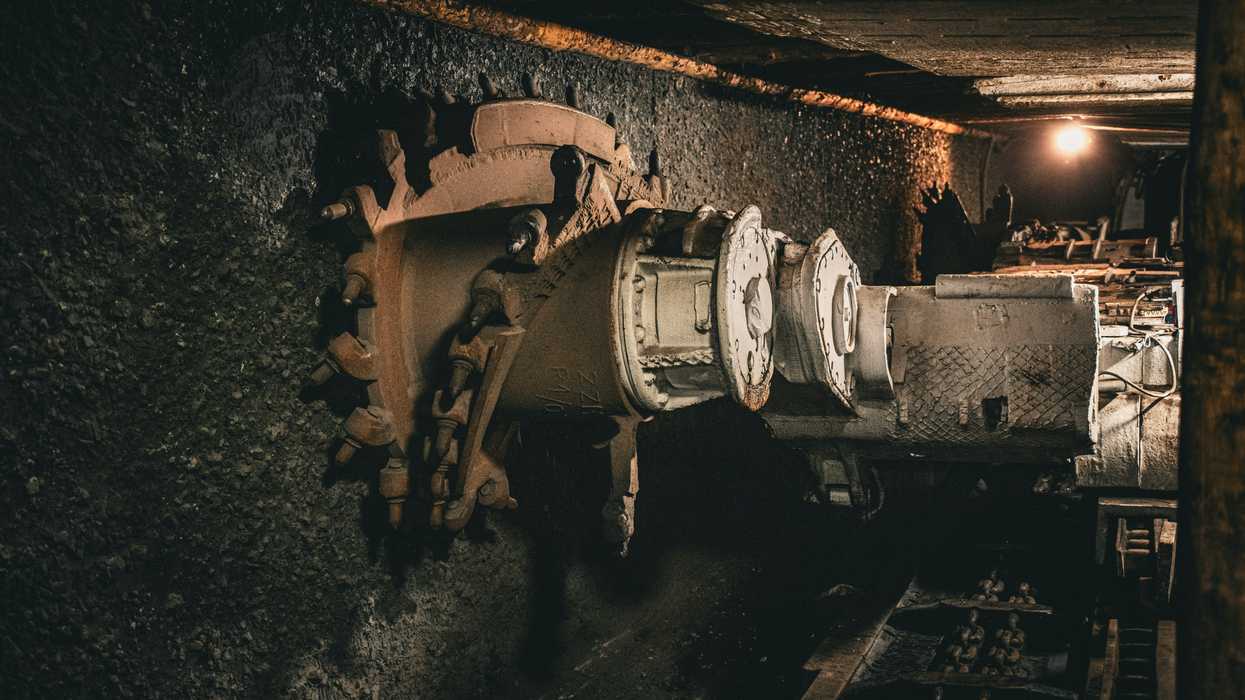 Coal mining equipment digging into a coal seam.
