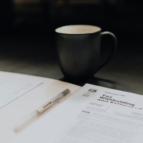 coffee mug near open folder with tax withholding paper.