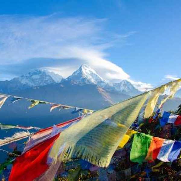 Colorful banners strung across a valley with snow-covered mountains in the background