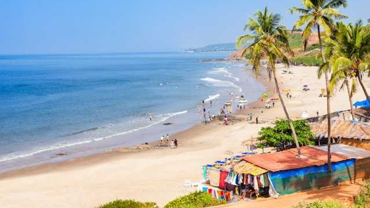 Colorful huts along a tropical beach with people on the sand