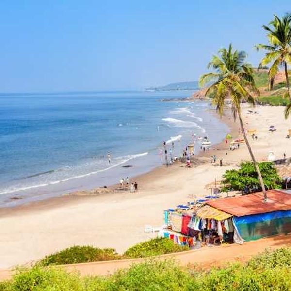 Colorful huts along a tropical beach with people on the sand