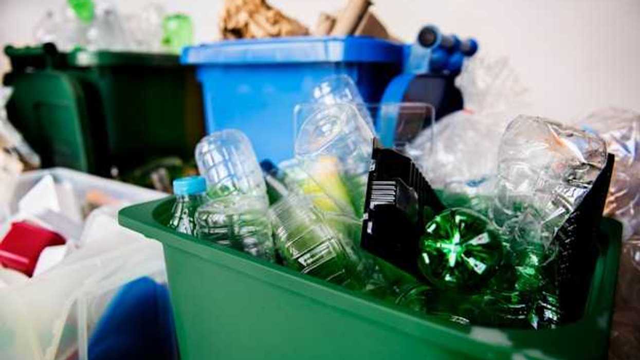 Containers of different colors holding different types of plastics and recyclables
