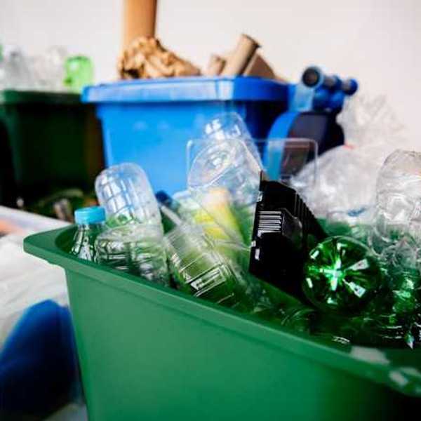 Containers of different colors holding different types of plastics and recyclables