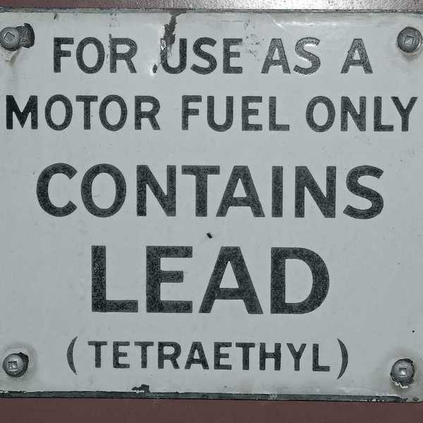 "Contains lead" fuel pump sign on side of antique gas station fuel pump