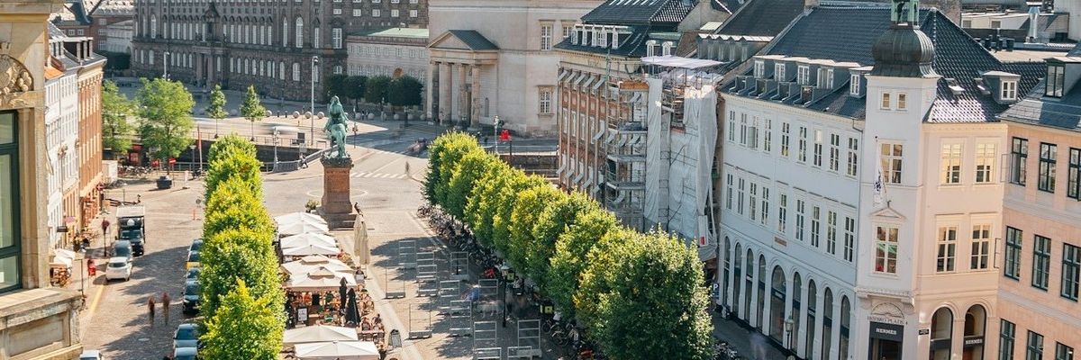 Copenhagen, Denmark central square viewed from above with bicycles, outdoor cafes and trees visible.
