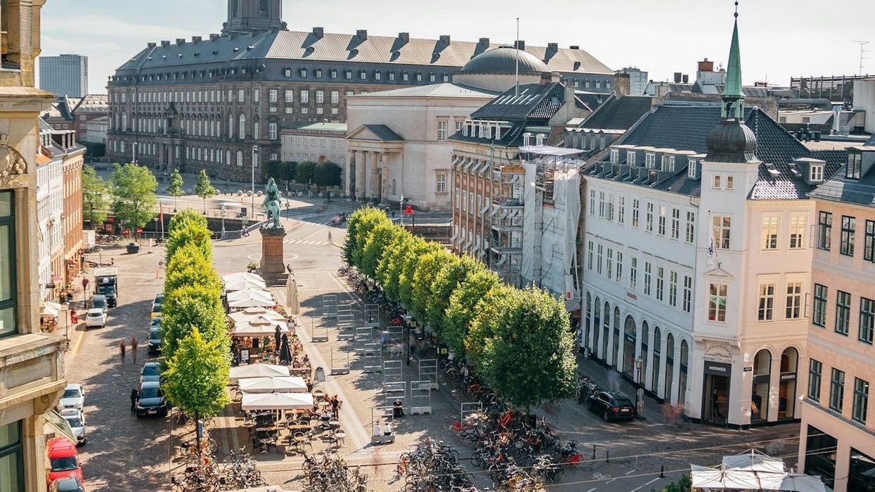 Copenhagen, Denmark central square viewed from above with bicycles, outdoor cafes and trees visible.