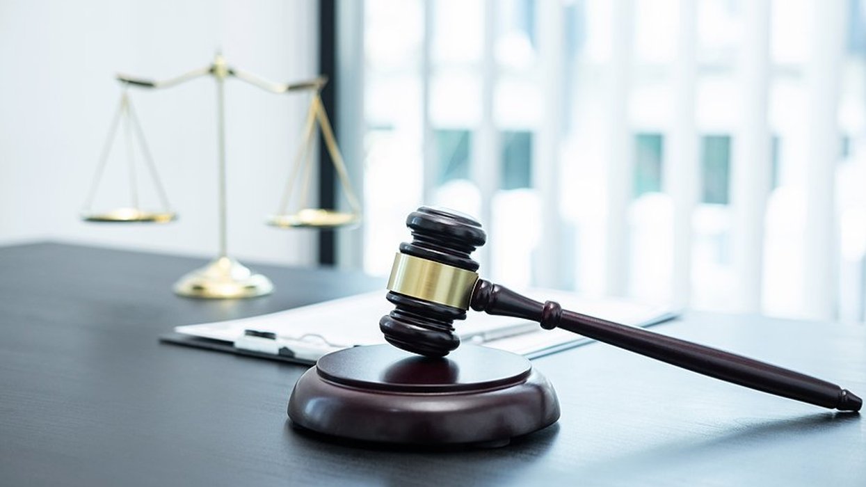Courtroom gavel with the scales of justice in the background