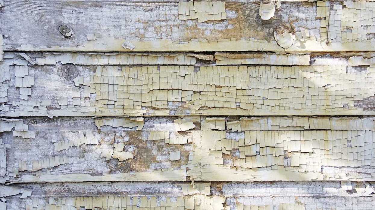 Cracked and rustic paint chipping off side of house or building