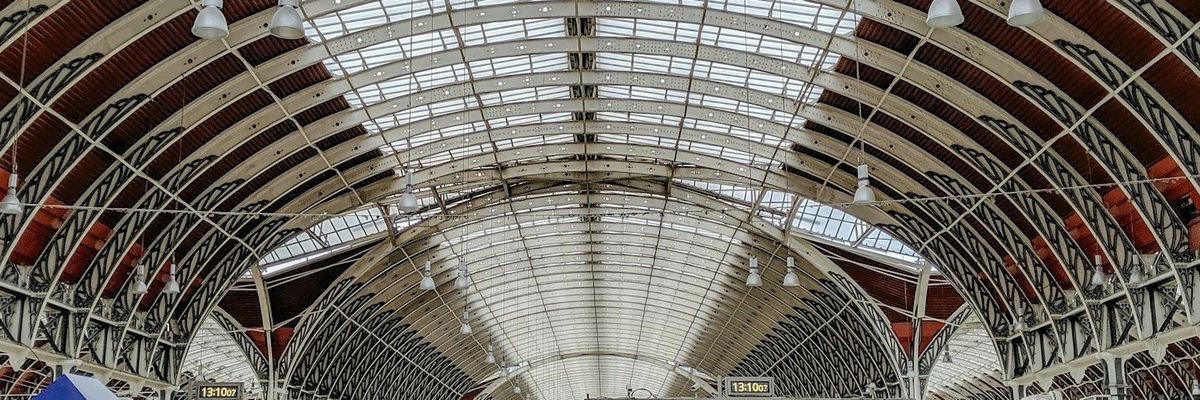 crowded airport terminal with arched glass ceiling.