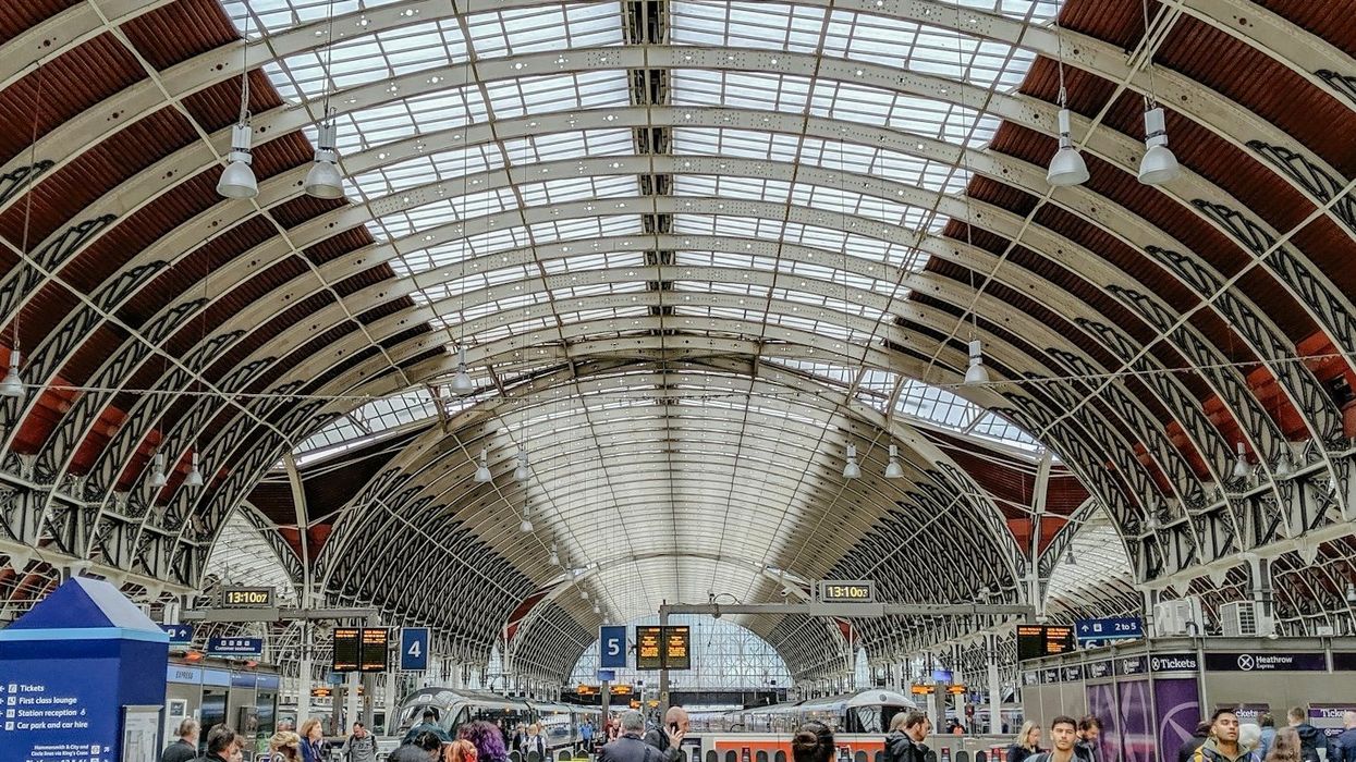 crowded airport terminal with arched glass ceiling.