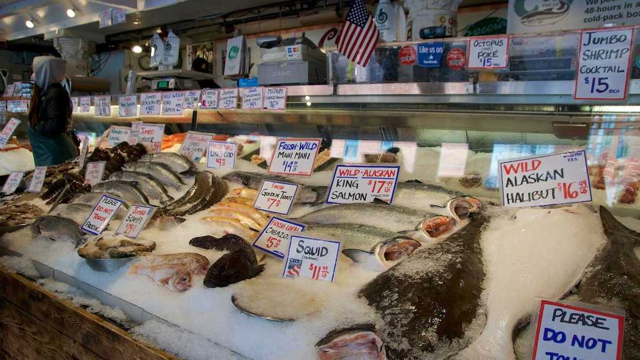 Customers at Pike Place Fish Company wait to order fish at the famous open air seafood market.