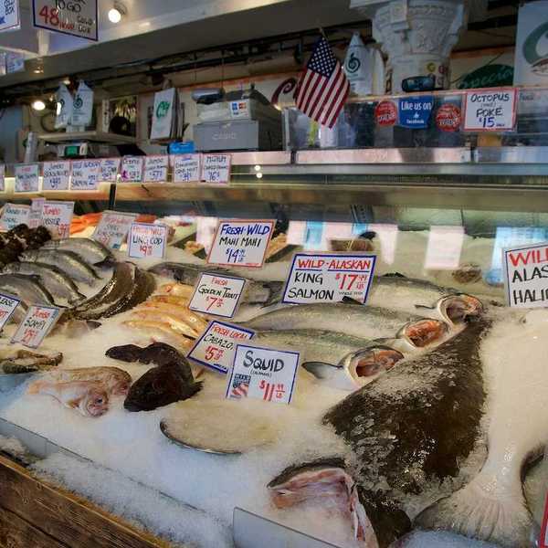 Customers at Pike Place Fish Company wait to order fish at the famous open air seafood market.