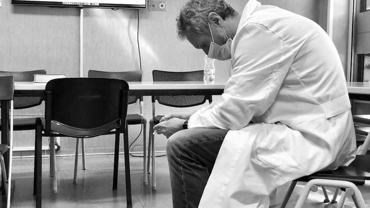 Dejected scientist in lab coat sitting in a chair