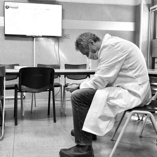 Dejected scientist in lab coat sitting in a chair